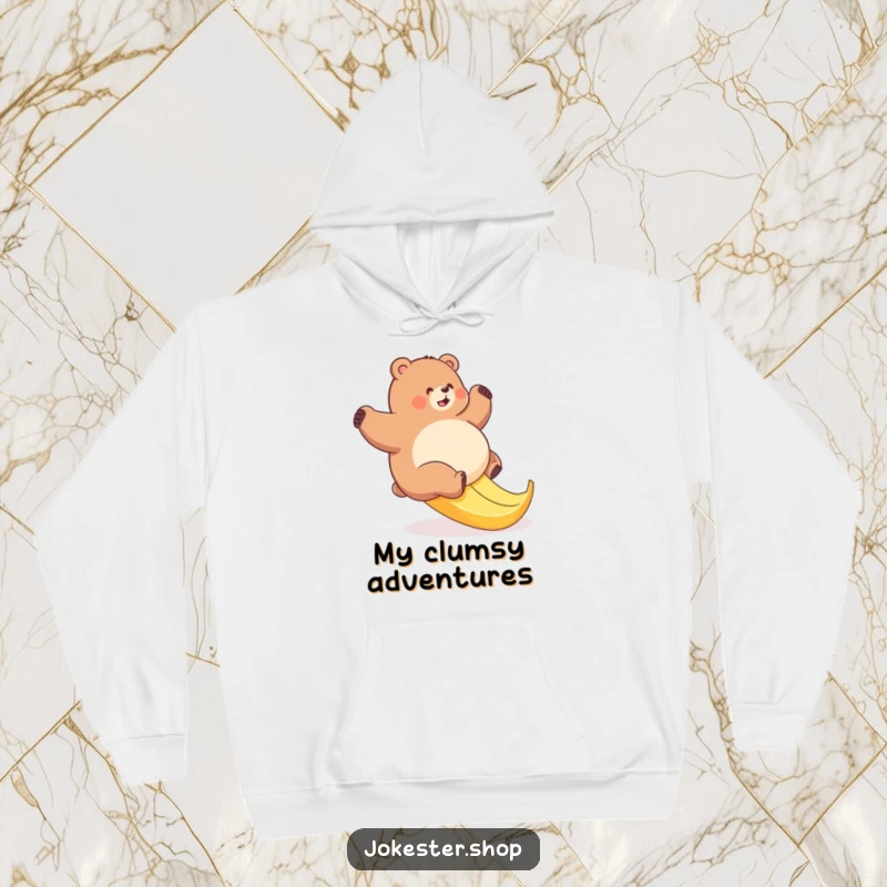Funny bear hoodie featuring a plump bear comically attempting to ascend a slick banana peel, perfect for cozy, humorous wear.