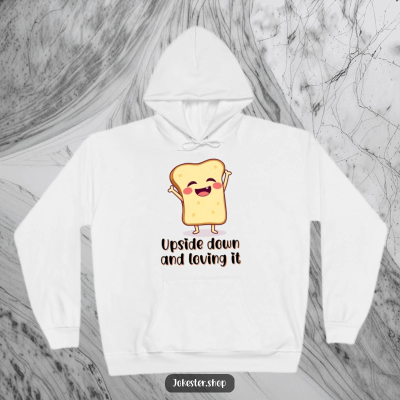 Funny hoodie depicting a giggling toast slice wobbling during a handstand attempt, soft and full of charm.